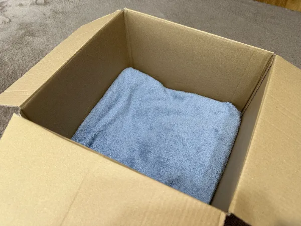 段ボール箱の中に入った折りたたまれた青いタオル